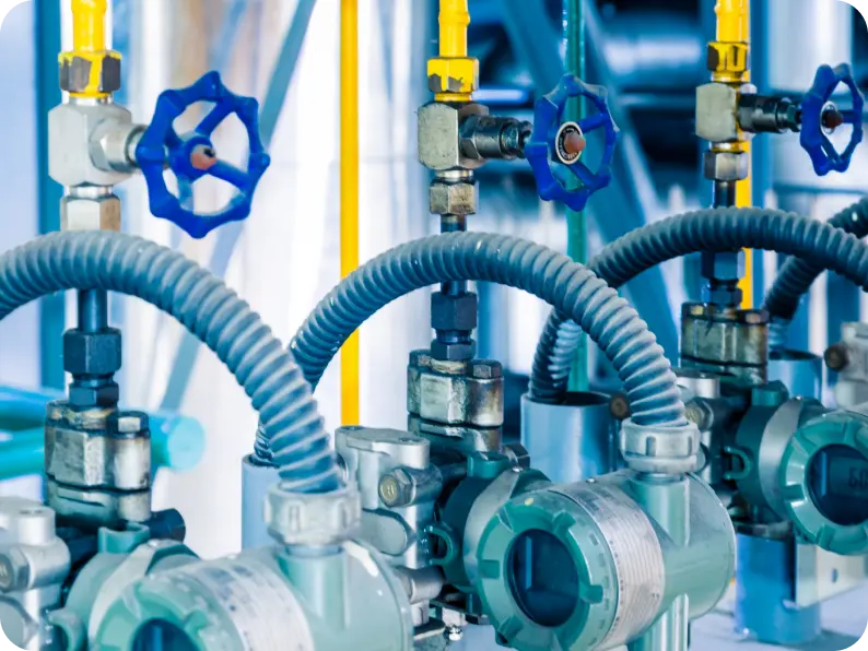 Industrial pipes with blue valve handles and flexible connections are meticulously arranged, showcasing the precision required in gas processing systems